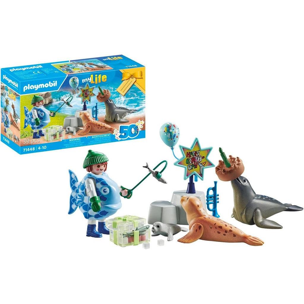 The Playmobil toy set is perfect for any birthday celebration, featuring seals, a figure wearing fins, and the role of Keeper with Animals. With fun accessories like an ice floe, musical instruments, and a "Happy Birthday" sign, it's a fantastic addition to any Toys &amp; Games collection. Box displayed in background.