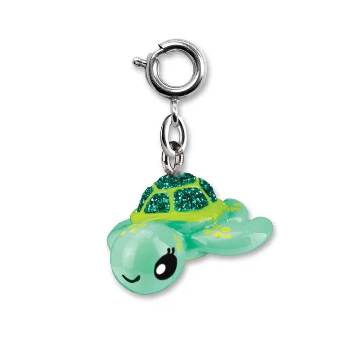 A small, glossy sea turtle charm with a smiling face. Its shell is green with glitter, reminiscent of the ocean, and it features a metal loop for easy attachment to your charm bracelet.