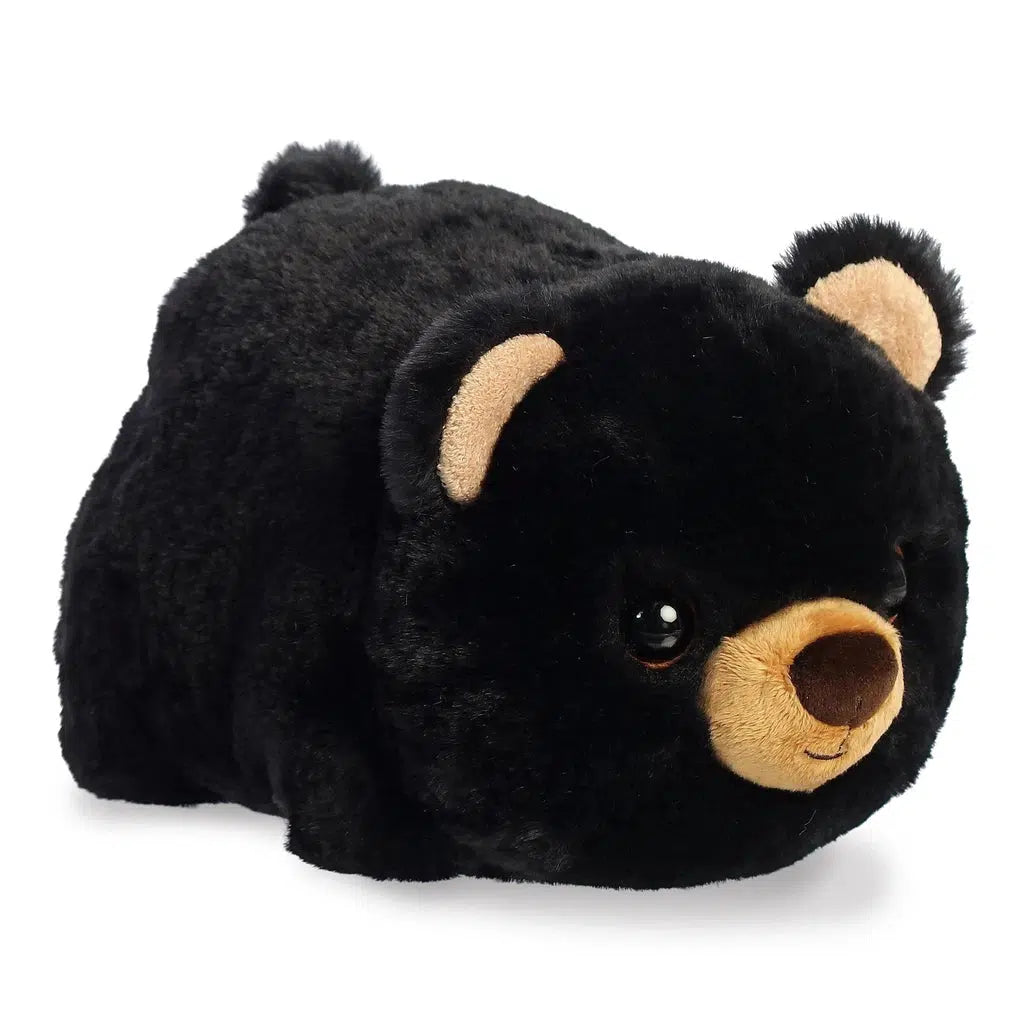 A plush black bear toy with a soft, round body and beige snout lies on a white background, making it a comforting gift.