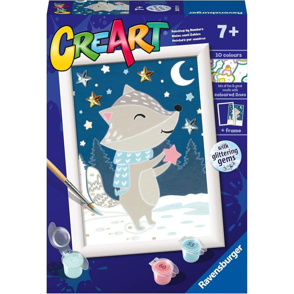 The Ravensburger CreArt painting-by-numbers kit showcases a cartoon fox in a scarf, holding a star amidst a winter scene with snow, stars, and a crescent moon. Complete with 10 colors and glittering gems for added magic.