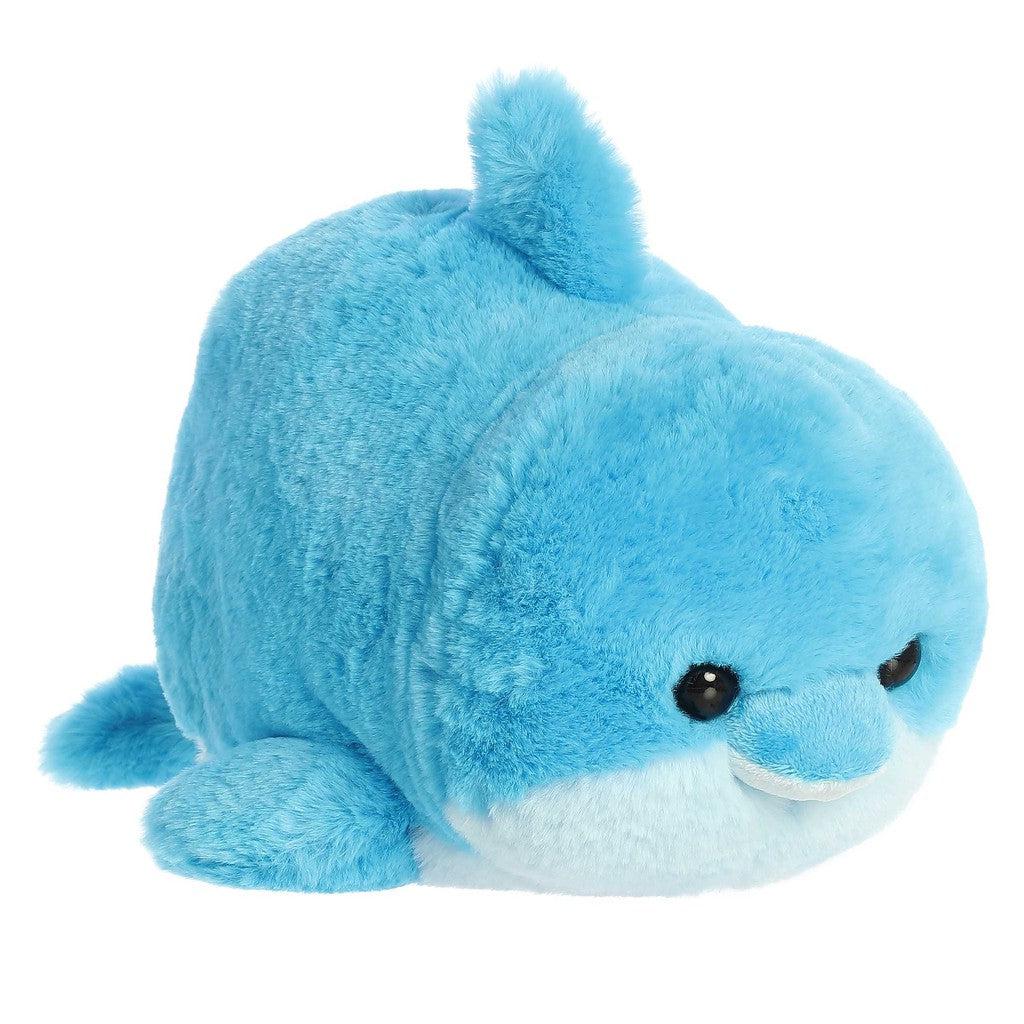 A round, plush blue dolphin toy known as Dilly Dolphin, features small black eyes and a light blue belly on a white background—perfect for marine lovers craving a cuddly companion.