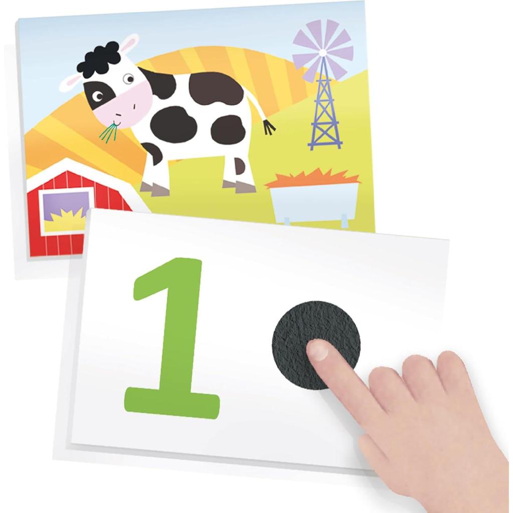 Image of a child pointing to a tactile black dot next to a large green number one. In the background, a cartoon farm scene with a cow, barn, windmill, and trough enhances this engaging toddler learning toy. Ideal for educational play with tactile numbers flash cards.