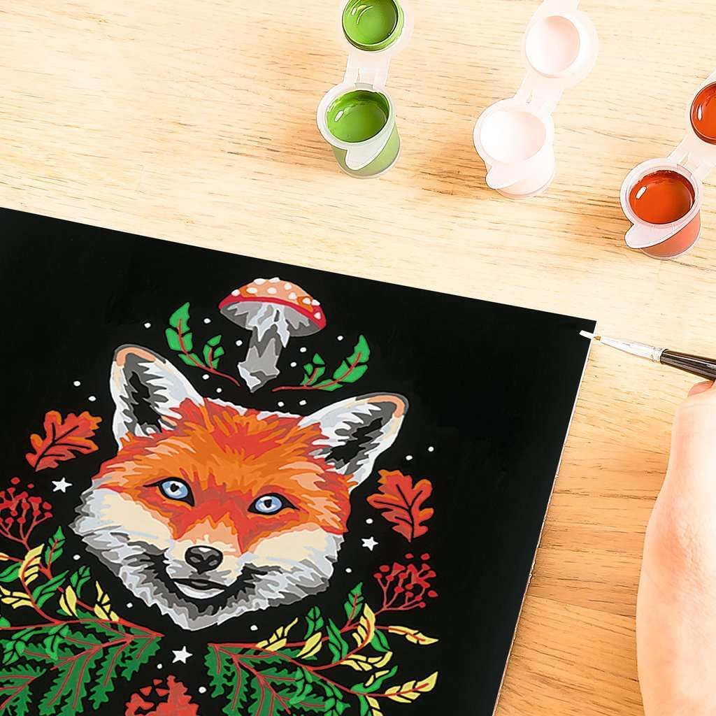 A hand painting a vibrant fox illustration on canvas, reminiscent of a Ravensburger Paint by Numbers Kit, with open paint pots nearby.