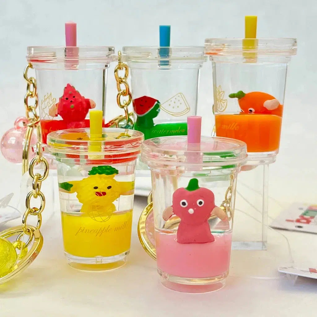 Five clear cups with colorful straws, each containing a fruit boba key charm that adds a playful touch to the ensemble.