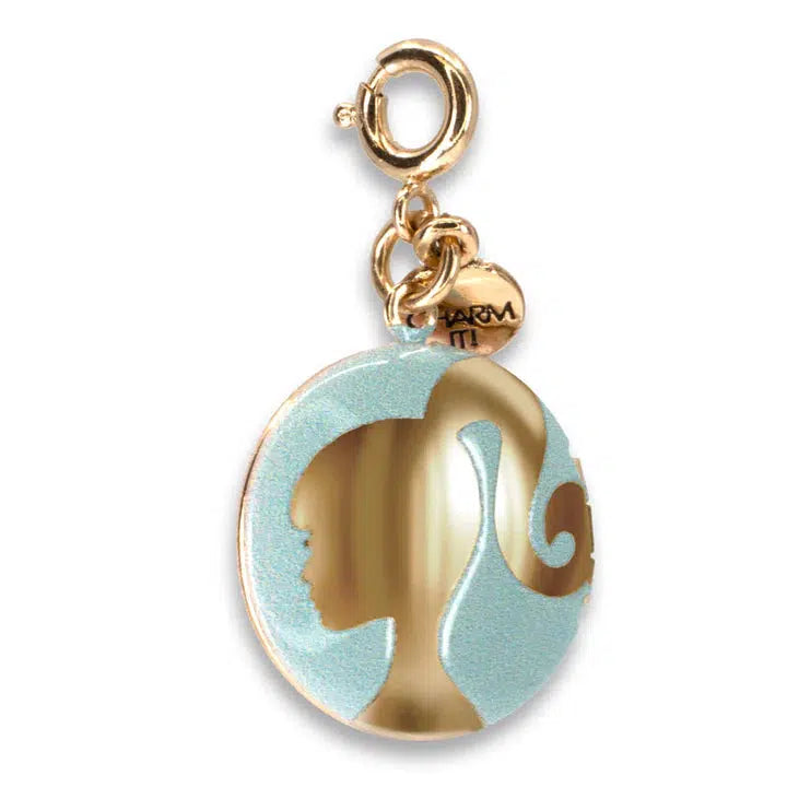 This Gold Barbie Locket features a charming silhouette of a girl with a ponytail, set against a light blue background. A small round tag elegantly adorns the top, making it an enchanting accessory for Barbie fans.