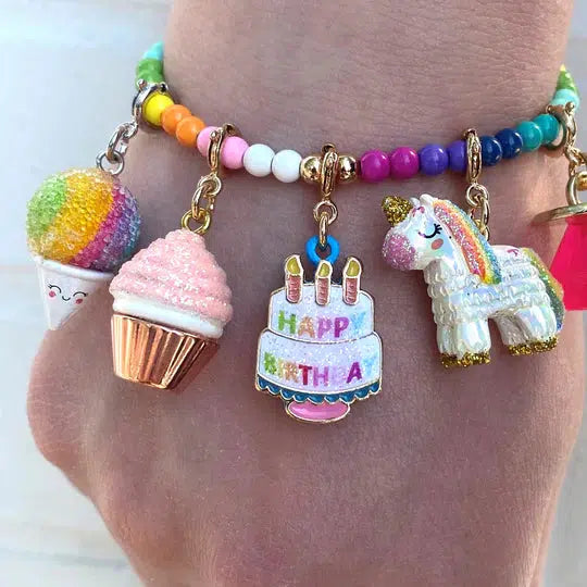 a wrist wearing a charm bracelet that has birthday-themed charms