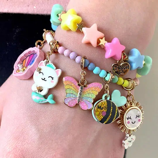 a wrist wearing rainbow-colored bracelet and charms