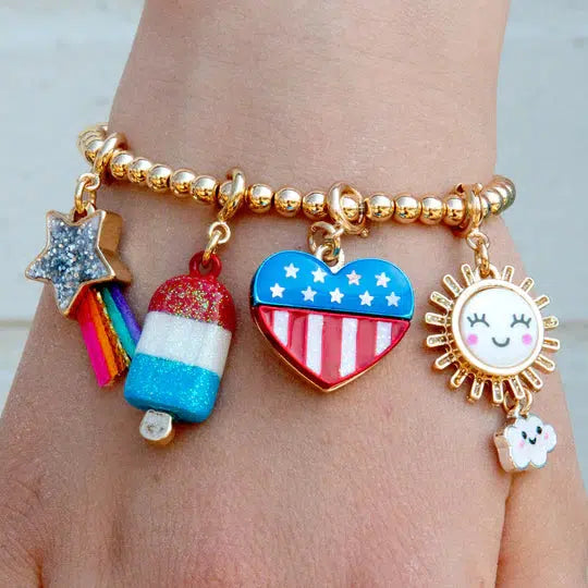 a wrist wearing a charm bracelet with patriotic theme