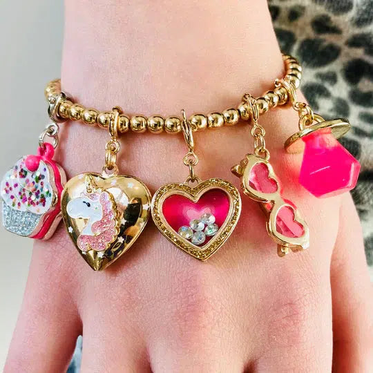 wrist wearing pink and gold charms