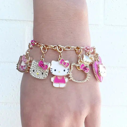 a wrist wearing a hello kitty charm bracelet