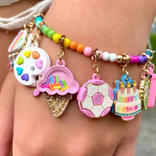 wrist wearing a charm bracelet with rainbow-colored charms