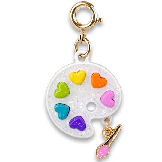 white charm shaped like a paint palette with rainbow heart-shaped paints and dangling paintbrush