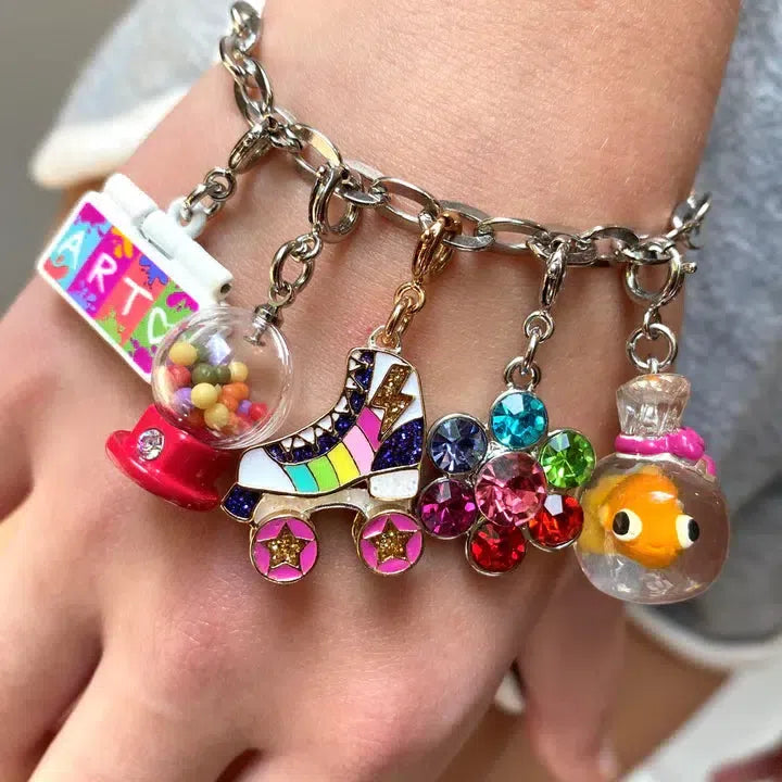 Close-up of a CHARM IT! bracelet adorned with charms like a candy machine, rainbow glitter roller skate, colorful flower, and fish in a bowl, all snugly worn on the wrist.