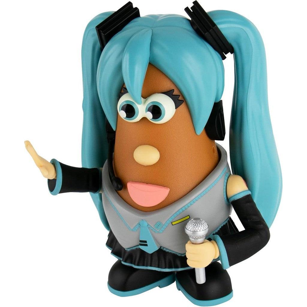 Side view of Mr Potato Head dressed as Hatsune Miku with long blue pigtails and a grey and black outfit. She is holding a microphone