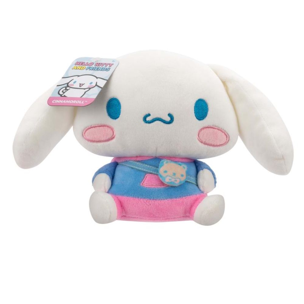 Cinnamoroll plush is sitting, wearing a blue and pink outfit and wearing a satchel