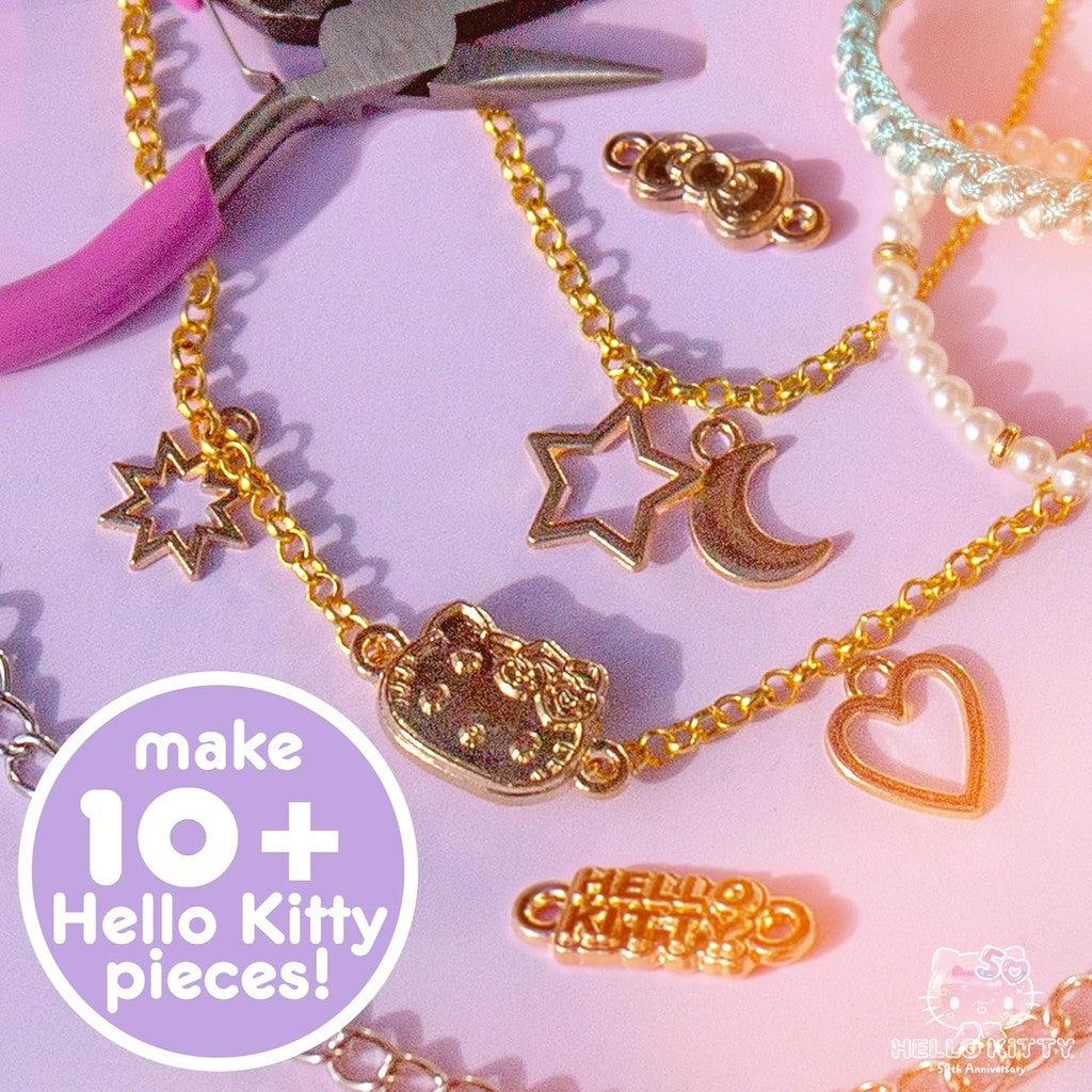 Sanrio's gold Hello Kitty-themed jewelry set sparkles on a purple surface, featuring necklaces adorned with star, moon, and heart charms. Dive into creativity and make 10+ unique Hello Kitty pieces with this delightful Jewelry Making Kit!.