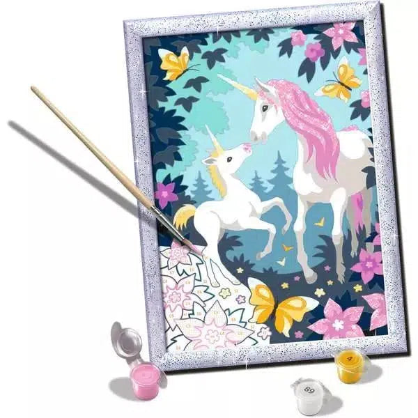 Painting kit featuring a framed image of two unicorns in a forest with butterflies. Paintbrush and small paint pots are included.