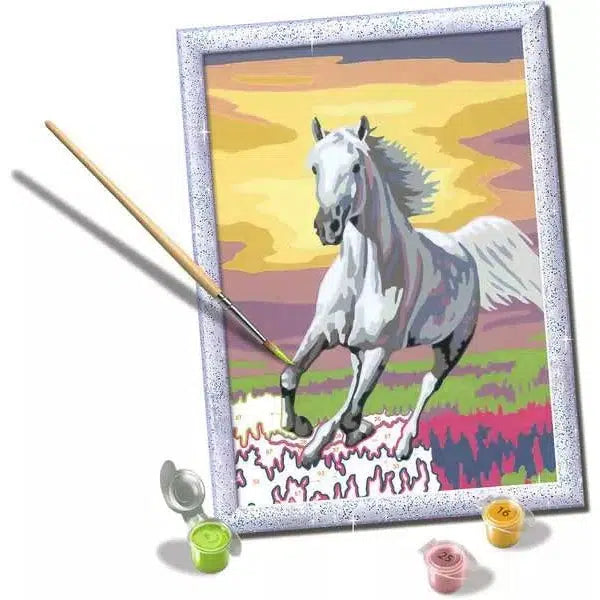 depicts a white horse galloping majestically at sunset in a vibrant landscape, complete with paint pots and a brush beside it.