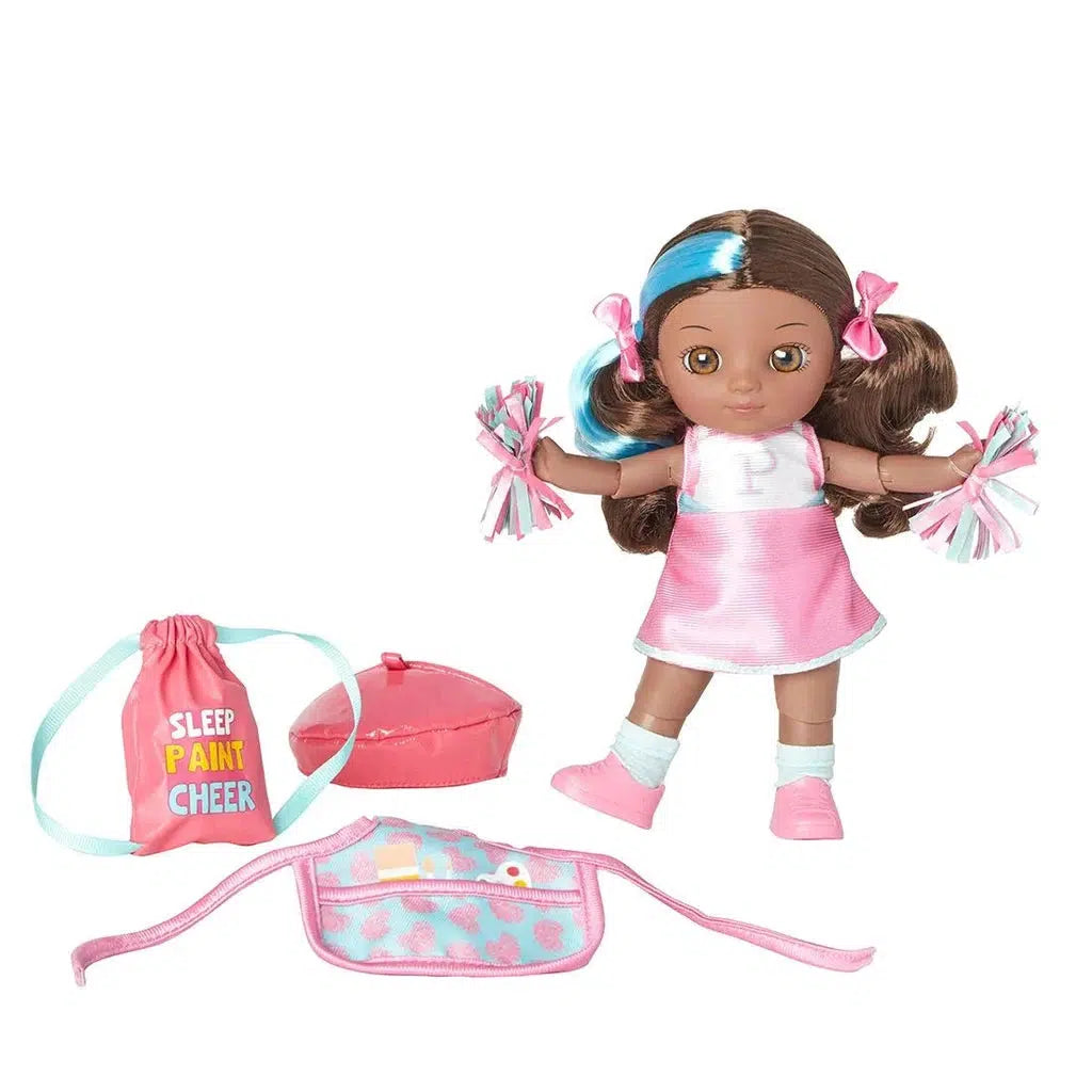 A posable Artist + Cheerleader doll, outfitted in a cheerleader uniform with pom-poms, comes with a paint-themed apron and beret. Tucked inside the pink drawstring bag with "Sleep Paint Cheer" is her collection of outfits and accessories.