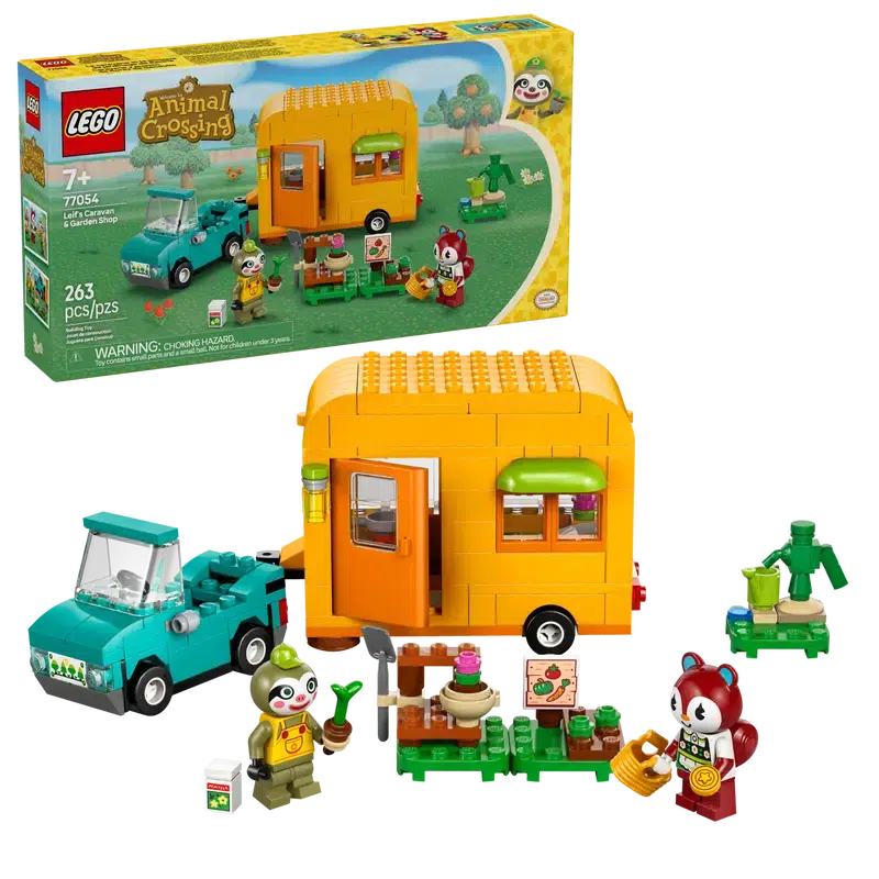 The lego set shown in front of it's box. There are two minifigs in front of a caravn and car next to a small lego garden