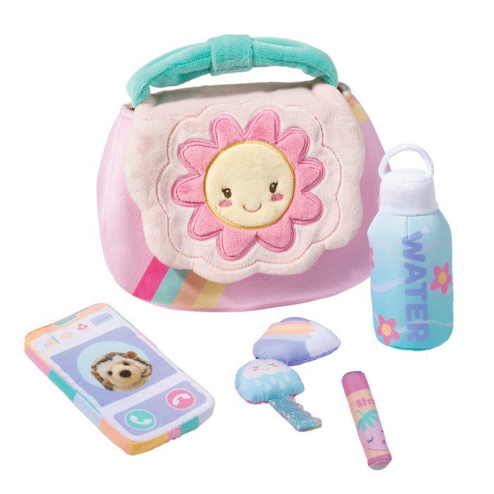 The Colorful toy set, titled "My First Purse," features plush accessories like a flower-themed purse, toy phone, cloud key, star-shaped lipstick, and water bottle, all with playful designs for imaginative adventures.