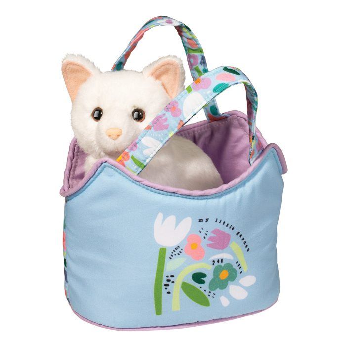 A plush white cat toy sits inside a blue fabric bag with floral designs and patterned handles, reminiscent of a charming Sassy Pet Sak.