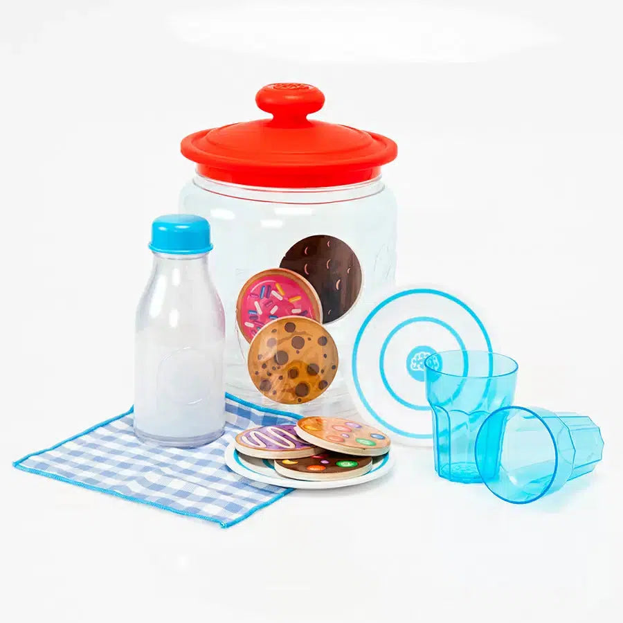 Toy cookie jar set with a red lid, plastic milk bottle, two blue cups, a blue checkered cloth, and assorted toy cookies with colorful designs.