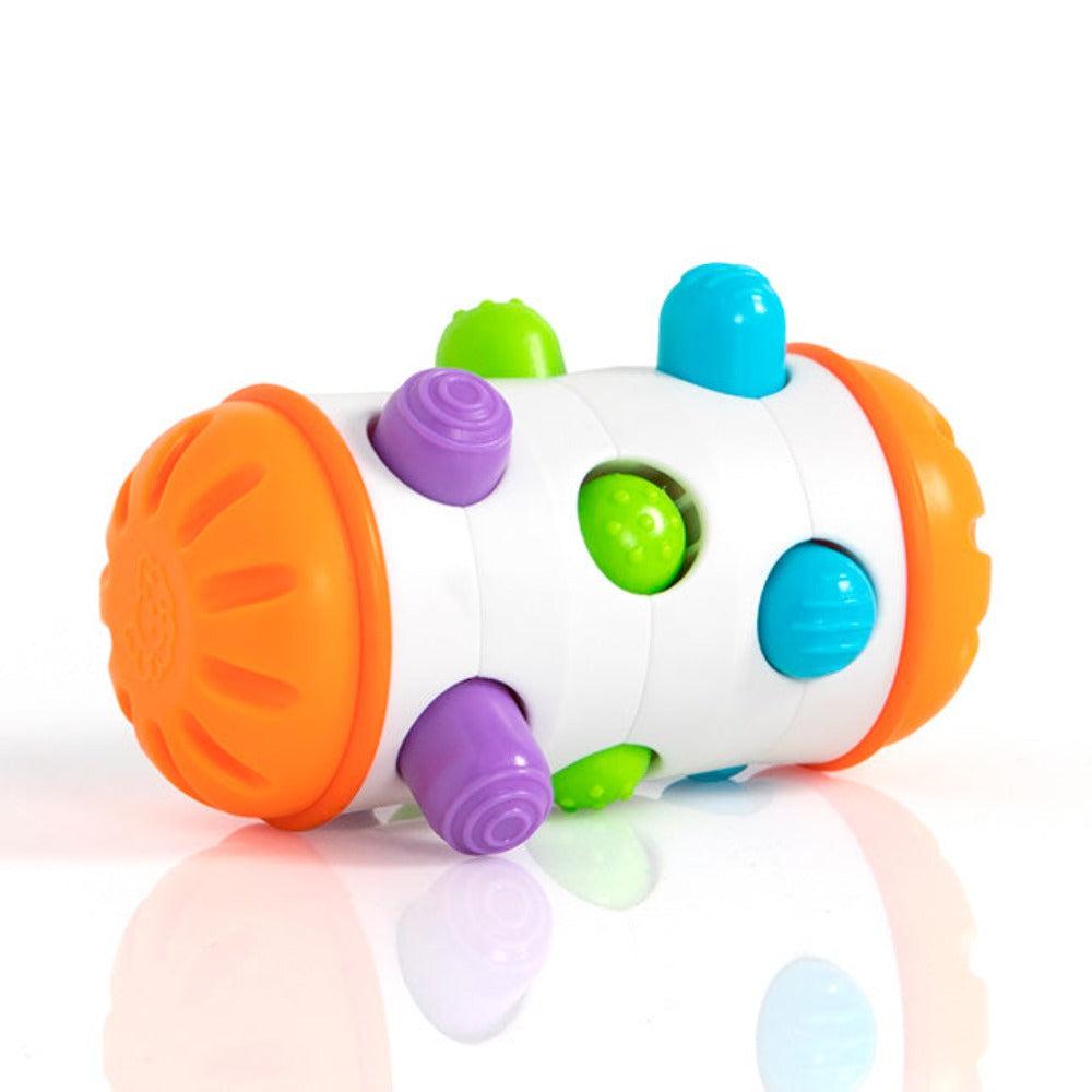 this image shows the baby toy rolio. its a capsule shaped toy with orange ends and a white body. the white cylinder has holes that have textured buttons that shake and slide around to stimulate a child.