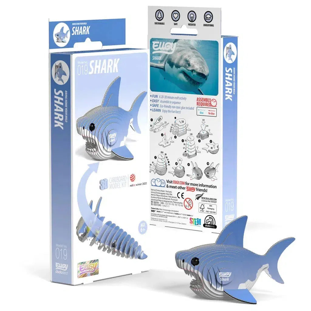 Packaging and components of a cardboard shark model kit, featuring eco-friendly materials. This 3D puzzle includes assembly instructions, a completed shark model, and flat cardboard sheets. Perfect for exploring STEM concepts while engaging in a fun, hands-on activity.