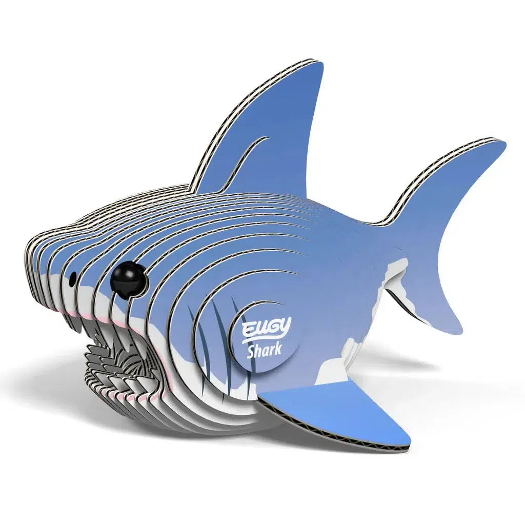 This eco-friendly 3D cardboard puzzle model of a shark features layered pieces in a blue and white color scheme, complete with a circular label reading "Shark." It's the perfect collectable toy for enthusiasts.