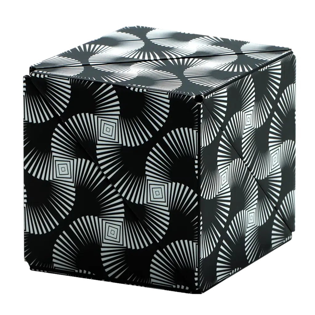 A Shashibo cube wrapped in black and white geometric patterned paper with spirals and squares, it cleverly conceals rare earth magnets that make it transformable into various mesmerizing shapes.