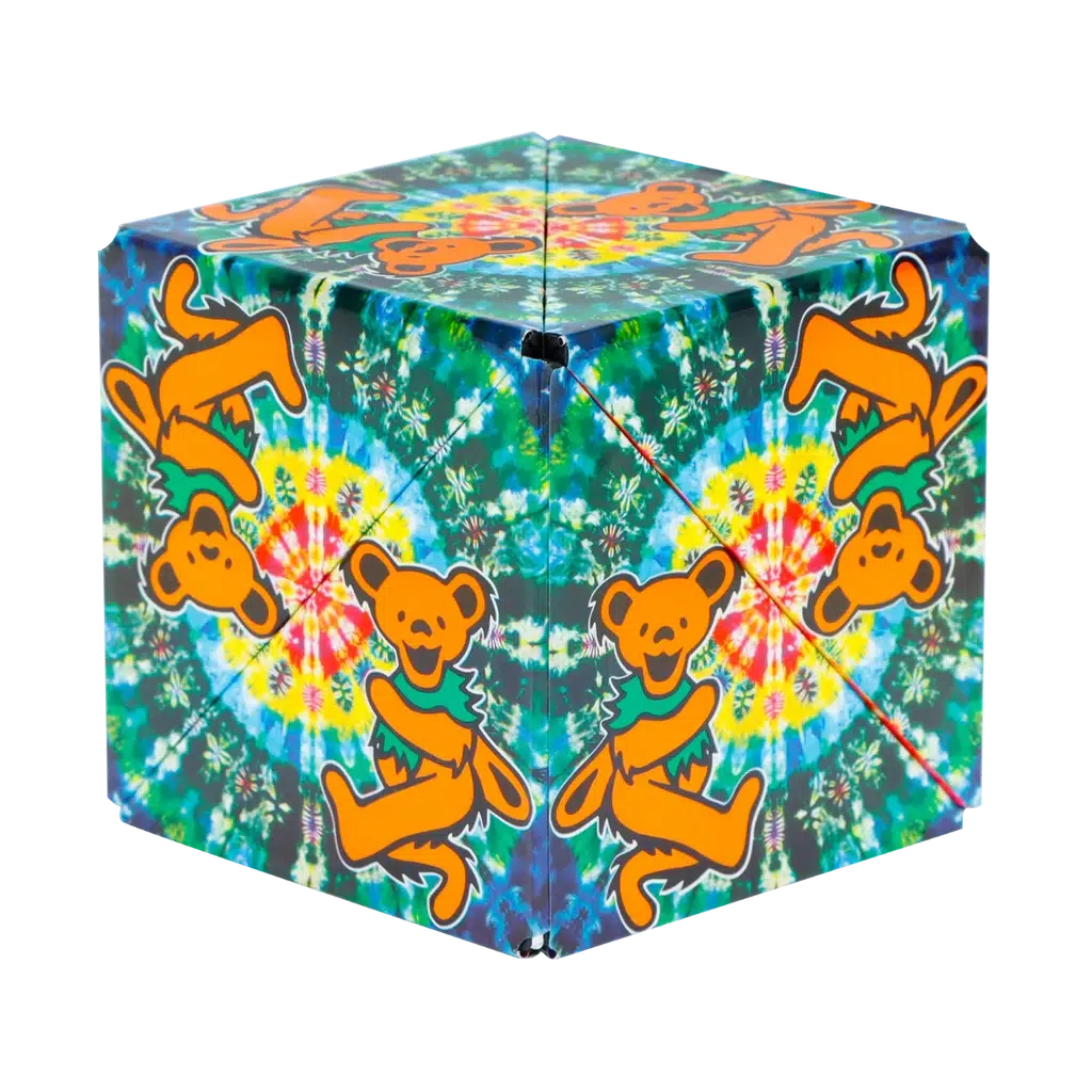 A colorful Shashibo cube with dancing bears and tie-dye patterns on each side transforms into mesmerizing shapes, captivating the imagination.