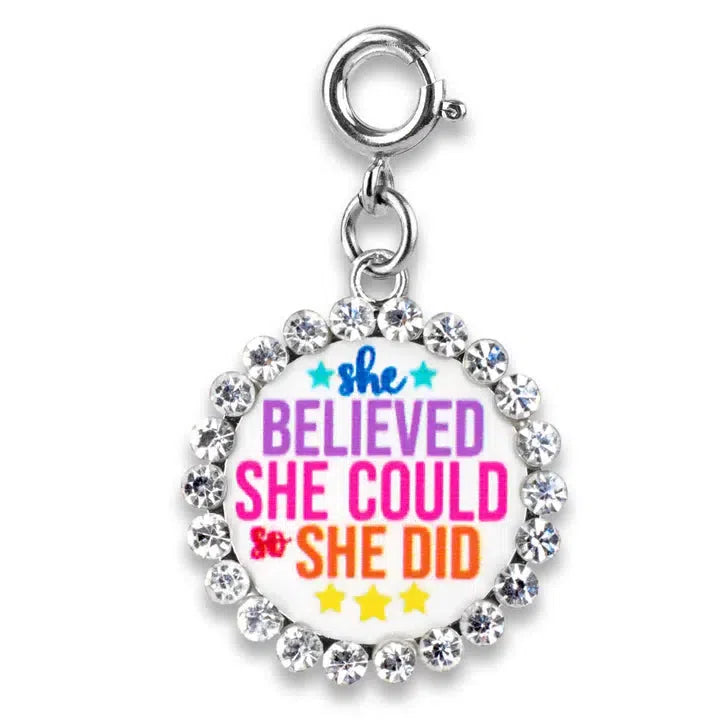 A round CHARM IT! piece, adorned with rhinestones, reads, "She believed she could so she did" in vibrant colors. Perfect to customize her collection with a touch of inspiration.