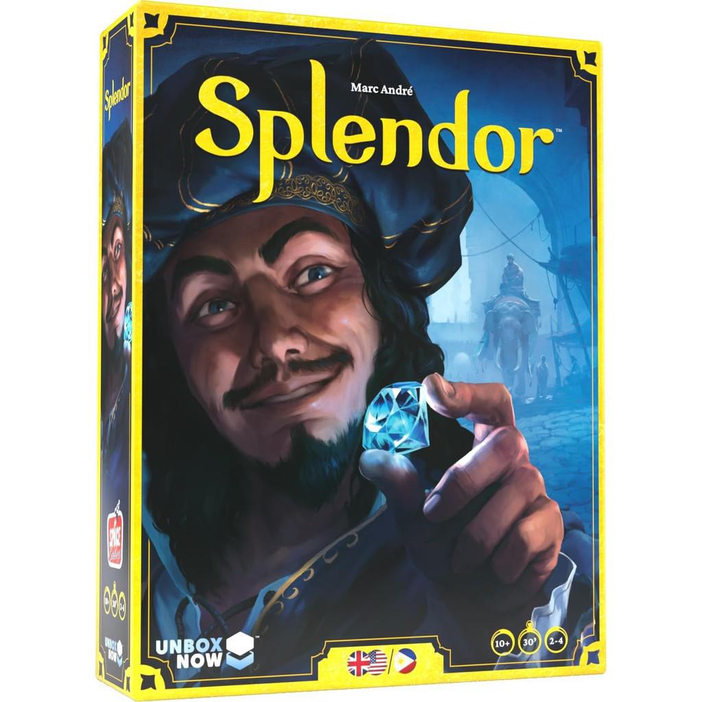 Box cover of the Splendor Board Game by Space Cowboys showcases an illustration of a man examining a gemstone against a medieval town backdrop, capturing the essence of this gem-minding strategy game. Game details and logos are elegantly placed at the bottom.