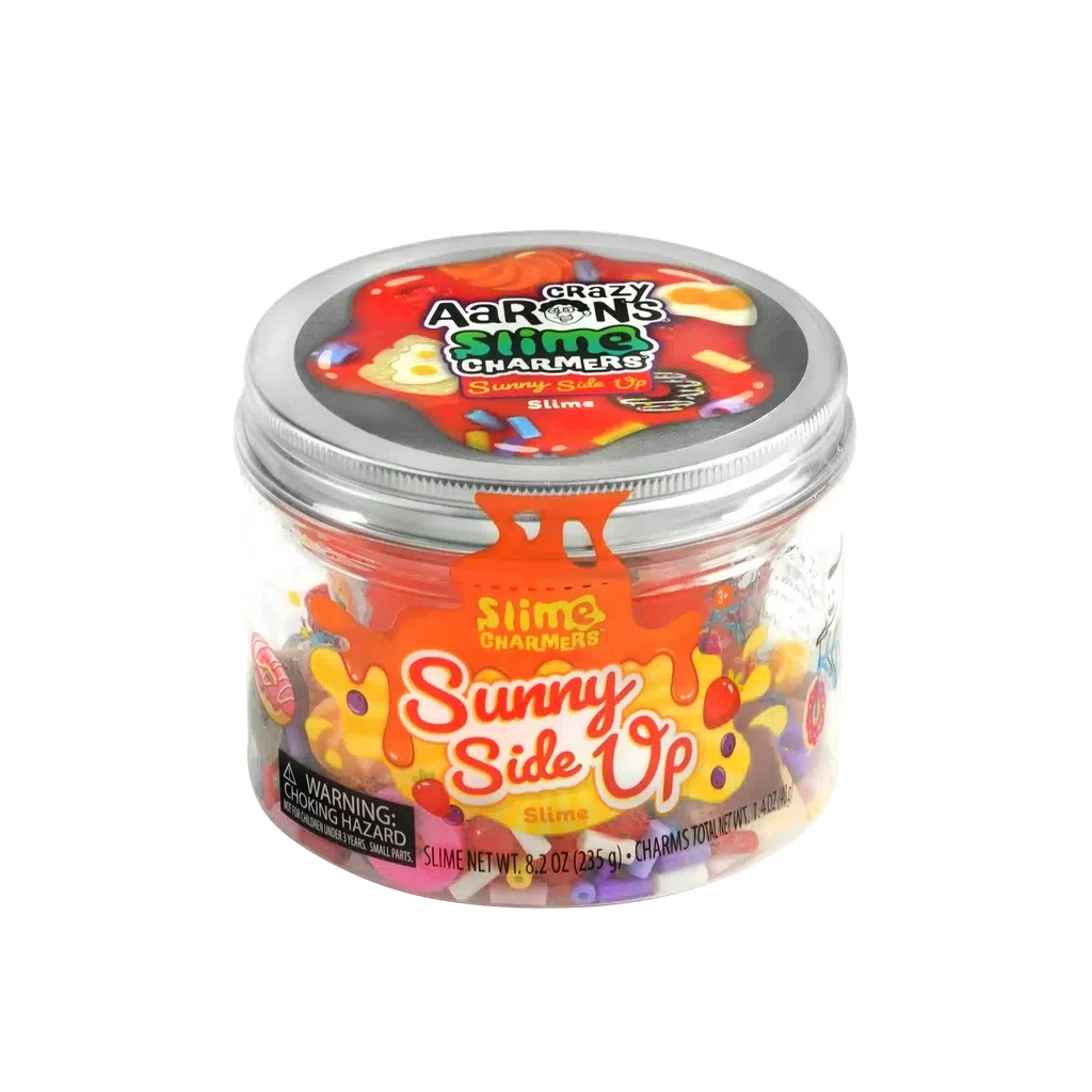 A clear plastic container labeled "Crazy Aaron's Slime Charmers" and "Sunny Side Up" is filled with vibrant slime charms. The background features a stunning gradient from purple to pink.