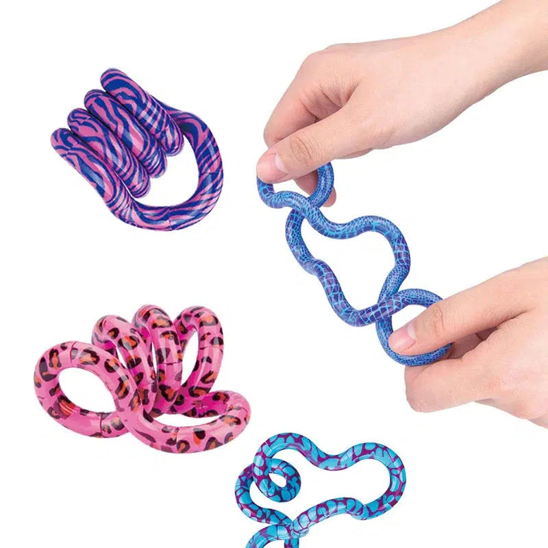 A hand is seen playing with a tangle with three others of different patterns are pictured to left. The tangle jr is a bunch of interconnected macaroni shaped pieces that can be twisted at the segments to make interesting shapes. Patterns detailed in following images.