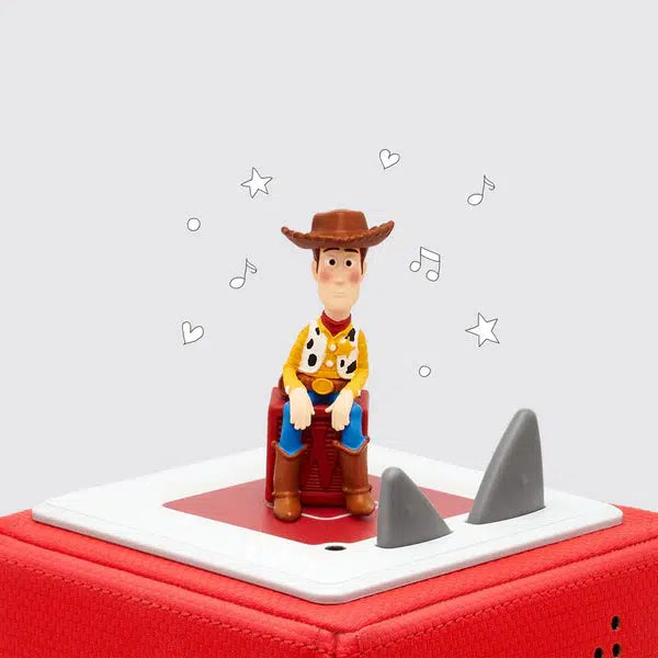 Tonie figure of the character Woody from toy story sitting on a wooden letter block and placed on a toniebox