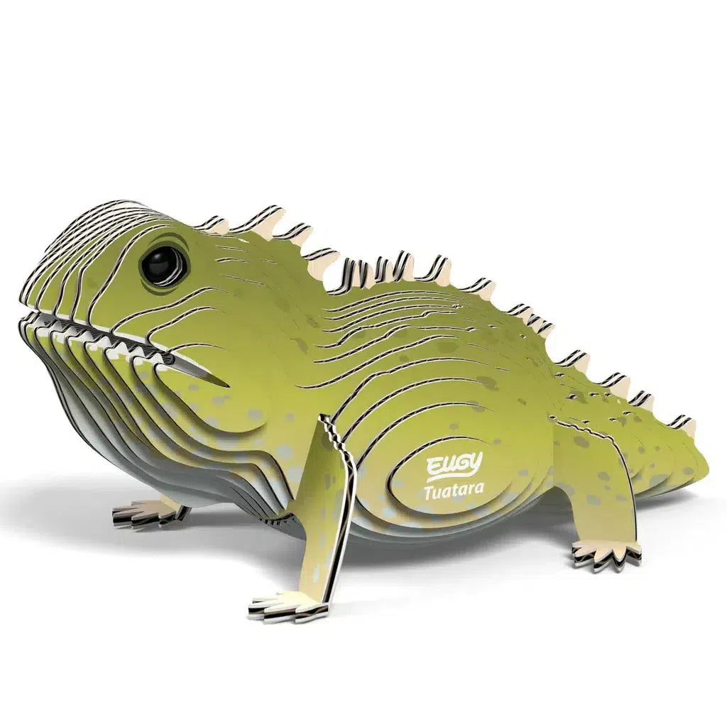 This eco-friendly 3D puzzle model of a tuatara features a layered construction with green and off-white sections and striking black eyes. "EUGY Tuatara" is proudly printed on its side, ensuring a unique piece for your collection.