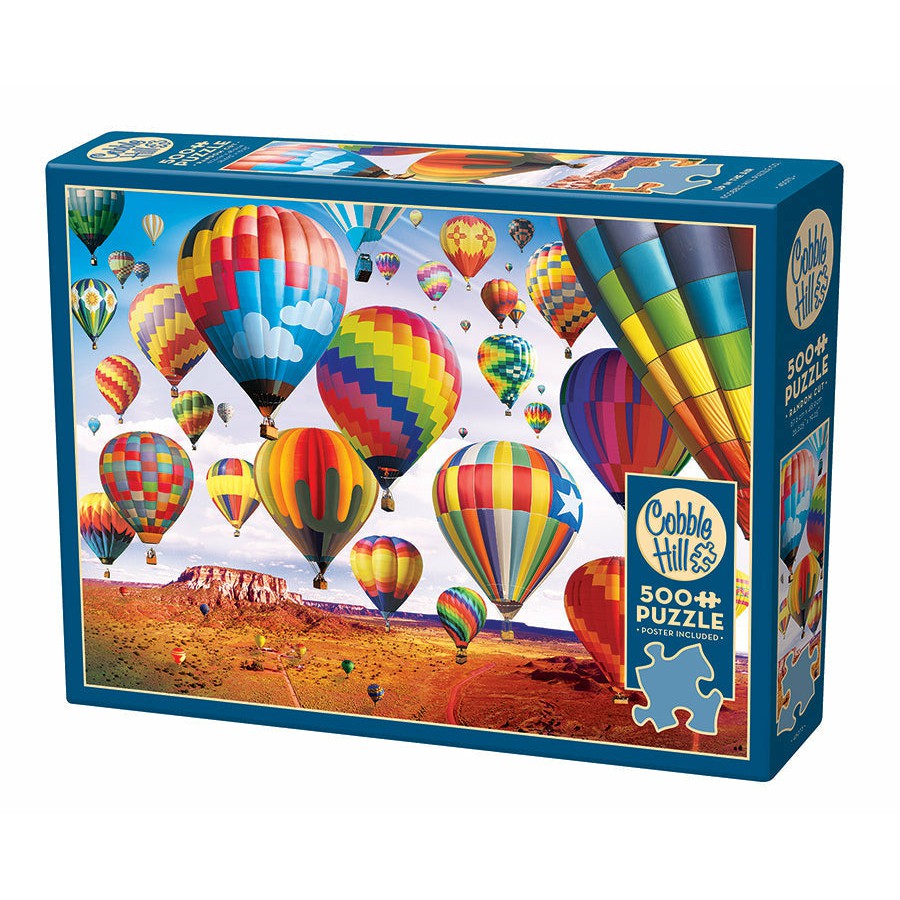 Box of a 500+ piece Cobble Hill puzzle featuring colorful hot air balloons floating over a desert landscape with a clear blue sky.