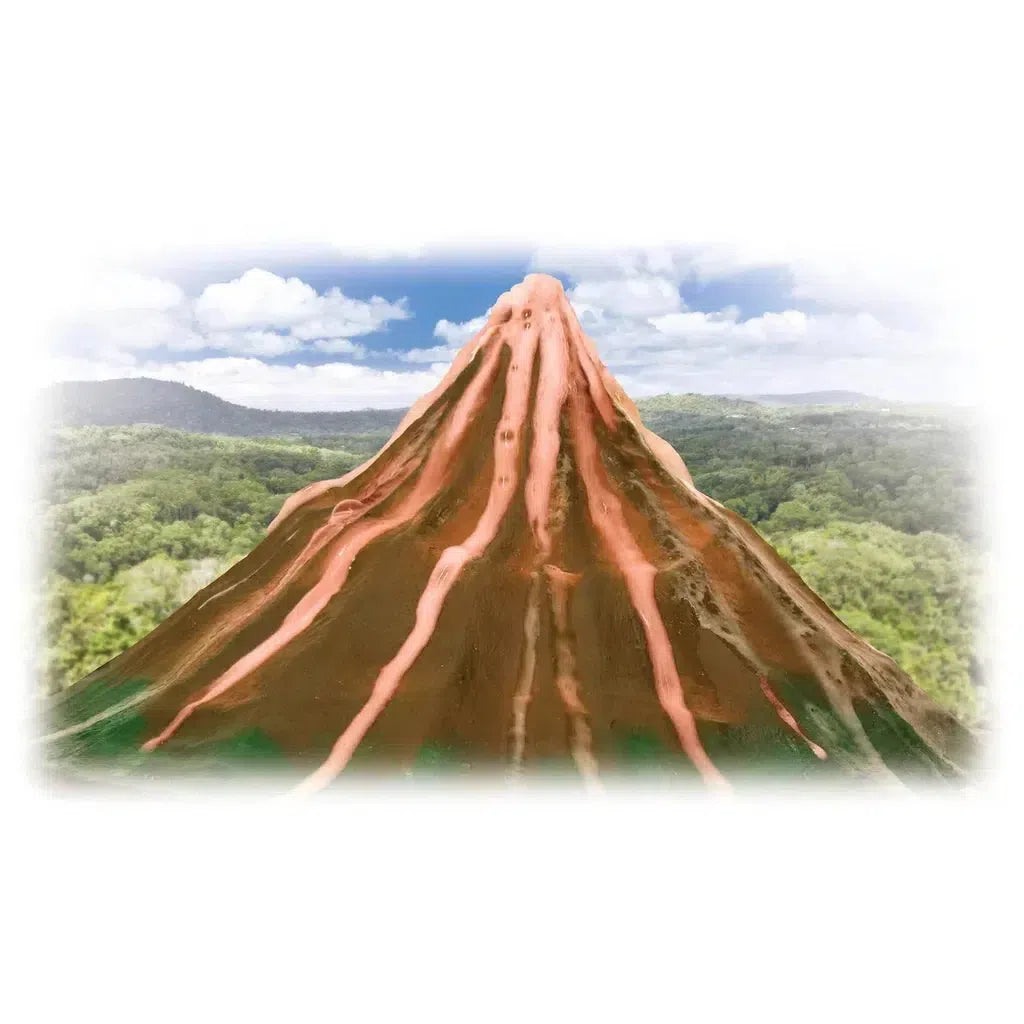 A model volcano, crafted to simulate an eruption with baking powder and vinegar, features red lava flows set against a lush green landscape under a partly cloudy sky.